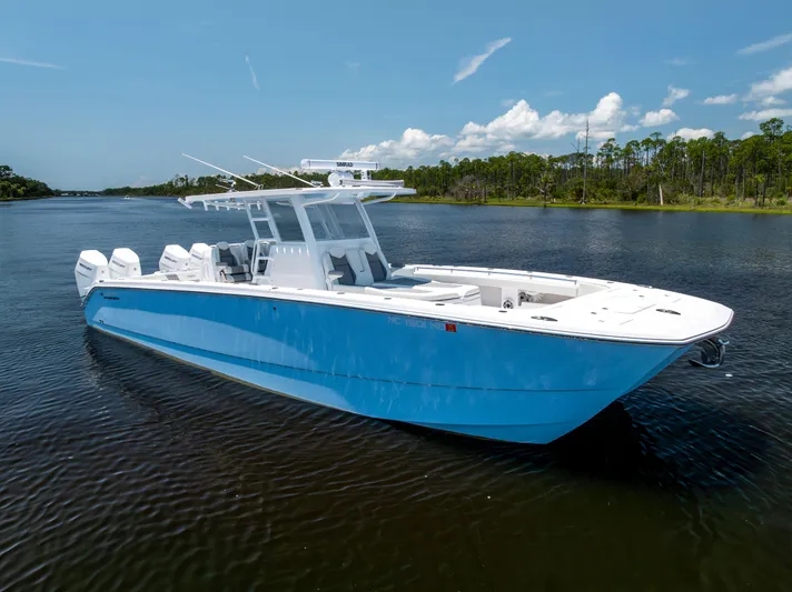  Yacht Photos Pics 2024 Invincible 37 Catamaran in blue, cruising on a serene lake under a clear sky.