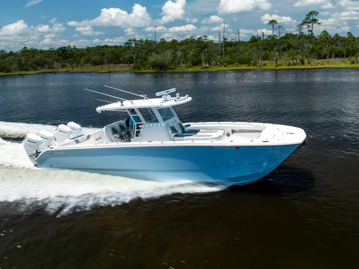  Yacht Photos Pics 2024 Invincible 37 Catamaran cruising on a scenic river under a clear blue sky.