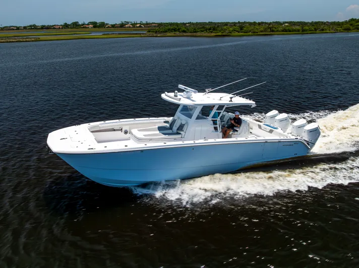  Yacht Photos Pics 2024 Invincible 37 Catamaran cruising on a calm river, showcasing sleek design and powerful engines.