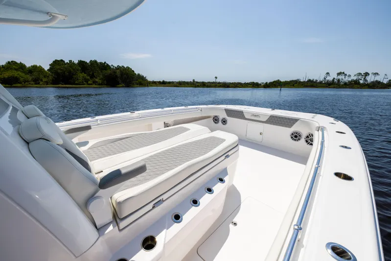  Yacht Photos Pics 2024 Invincible 37 Catamaran boat interior with cushioned seating on calm water.