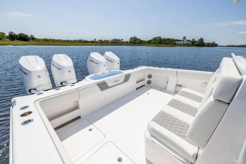  Yacht Photos Pics 2024 Invincible 37 Catamaran with four Mercury engines on a serene waterway.