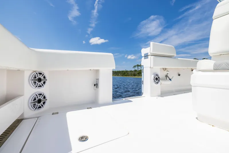  Yacht Photos Pics 2024 Invincible 37 Catamaran deck with speakers, white seating, and scenic water view.