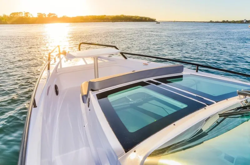  Yacht Photos Pics 2025 Axopar 37 Sun Top BRABUS Trim boat on serene water at sunset.
