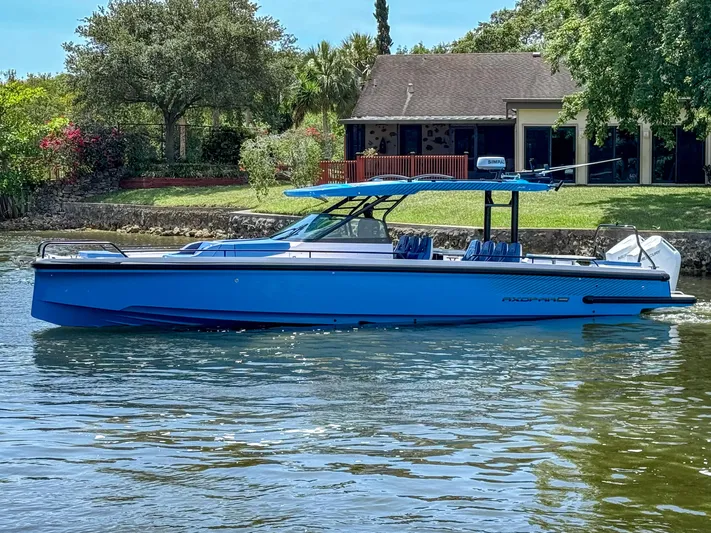  Yacht Photos Pics 2025 Axopar 37 Sun Top BRABUS Trim boat on calm water near a house.