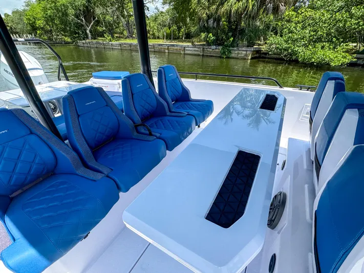  Yacht Photos Pics 2025 Axopar 37 Sun Top BRABUS Trim with blue seating and sleek table design.