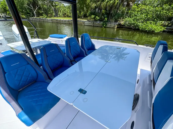  Yacht Photos Pics 2025 Axopar 37 Sun Top BRABUS Trim with blue seating and sleek table on a sunny day.