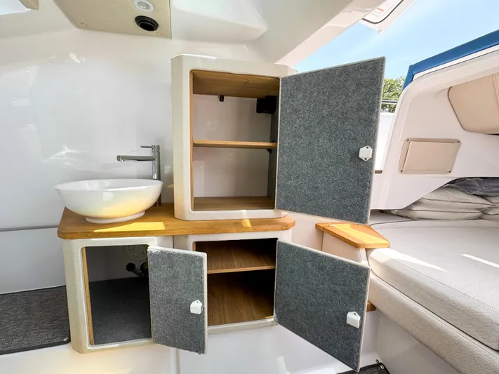  Yacht Photos Pics 2025 Axopar 37 Sun Top BRABUS Trim interior with open cabinets and modern sink.