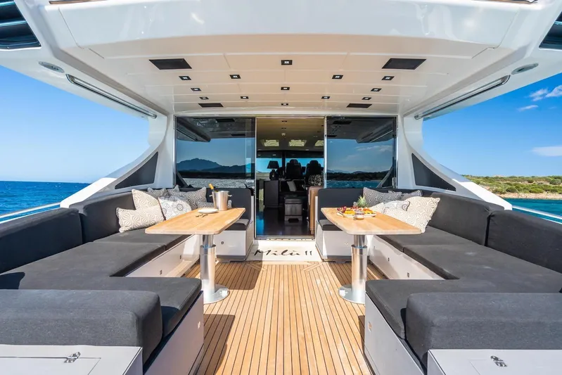 MilÙ II Yacht Photos Pics Luxurious 2009 Overmarine Mangusta 80 yacht deck with elegant seating and ocean view.