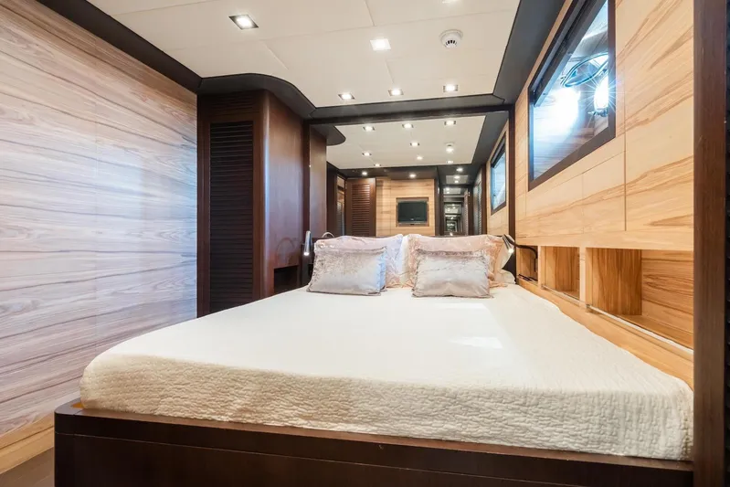 MilÙ II Yacht Photos Pics Luxurious bedroom interior of 2009 Overmarine Mangusta 80 yacht with modern wood paneling.