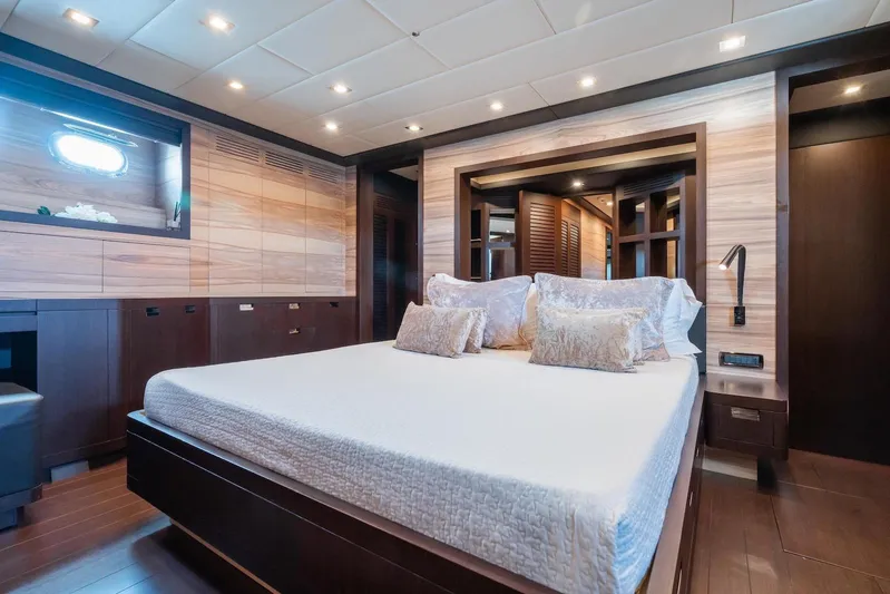 MilÙ II Yacht Photos Pics Luxurious bedroom interior on 2009 Overmarine Mangusta 80 yacht, featuring elegant wood finishes.