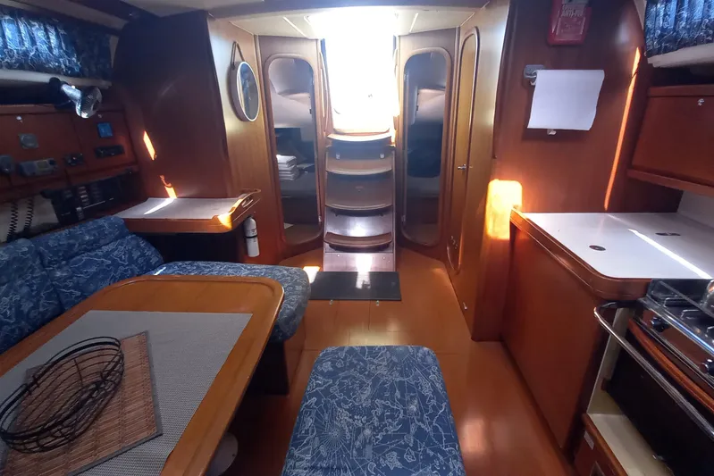 We Reach Yacht Photos Pics Interior of 2011 Dufour 425 Grand Large yacht with wood finish and blue upholstery.