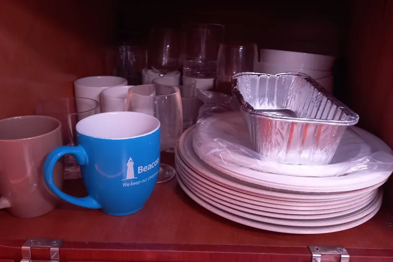 We Reach Yacht Photos Pics Cabinet with mugs, glasses, plates, and foil trays on a 2011 Dufour 425 Grand Large.