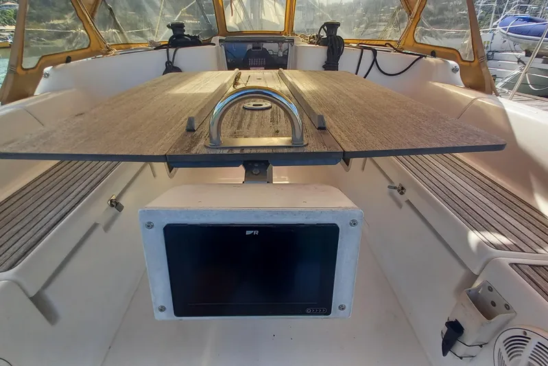 We Reach Yacht Photos Pics Cockpit of 2011 Dufour 425 Grand Large sailboat with wooden table and navigation equipment.