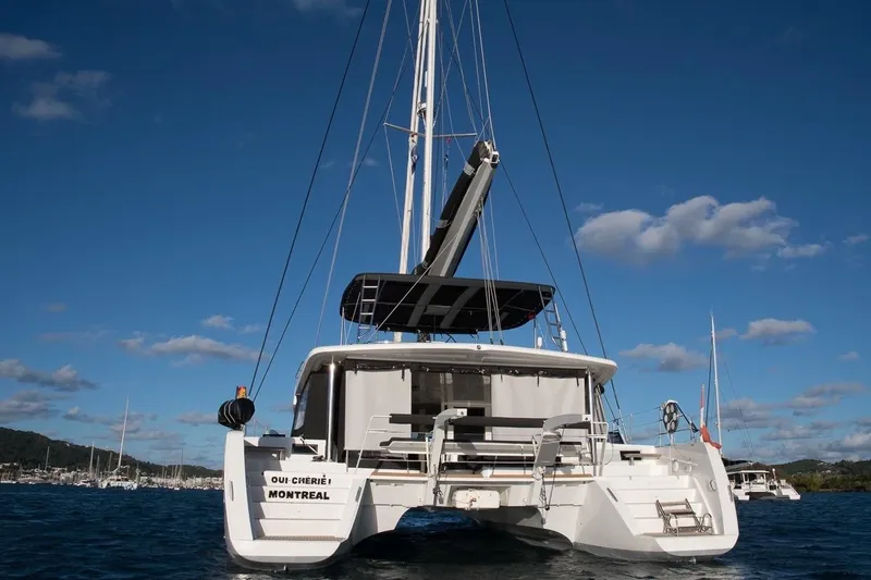 Oui Cherie Yacht Photos Pics 2017 Lagoon 52 F catamaran on water, rear view, under clear blue sky.