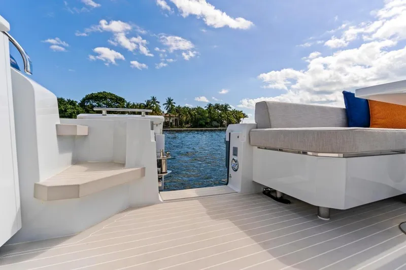  Yacht Photos Pics 2024 Uniesse Exuma HTC5p yacht deck with seating, overlooking serene water and blue sky.