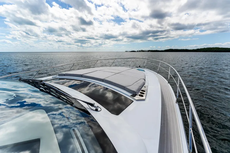  Yacht Photos Pics 2024 Uniesse Exuma HTC5p yacht cruising on open water under a partly cloudy sky.