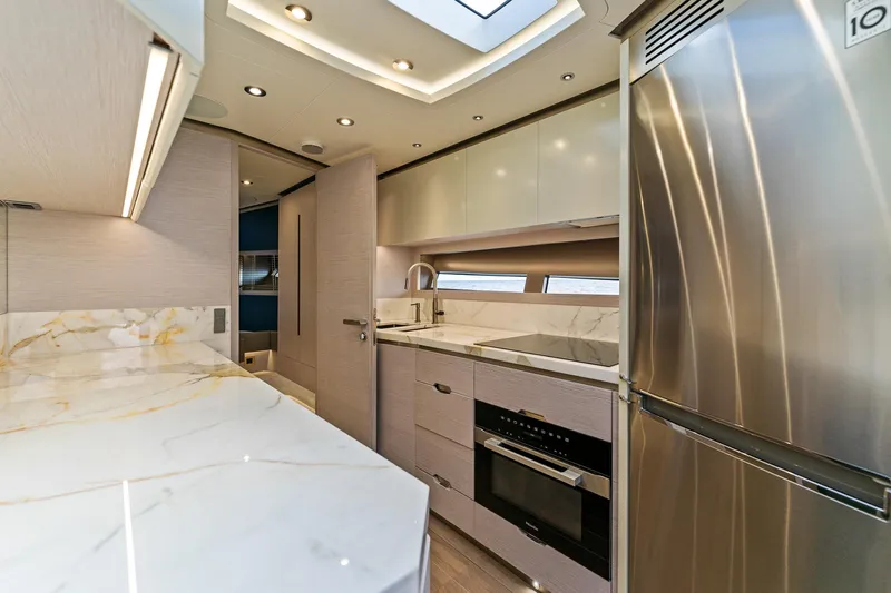  Yacht Photos Pics Luxurious 2024 Uniesse Exuma HTC5p yacht kitchen with modern appliances and elegant marble countertops.