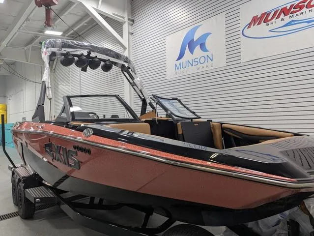 2025 Axis Wake Research A225 boat in showroom, Munson Surf & Wake signage visible.