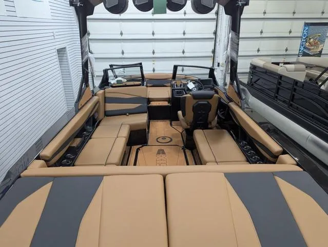 2025 Axis Wake Research A225 boat interior with tan and gray seating in a garage.