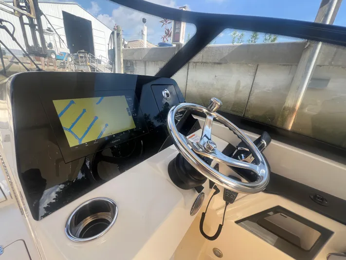  Yacht Photos Pics 2025 Scout 277 Dorado boat dashboard with steering wheel and navigation display.