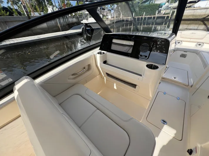 Yacht Photos Pics 2025 Scout 277 Dorado boat interior with seating and dashboard, docked by the water.