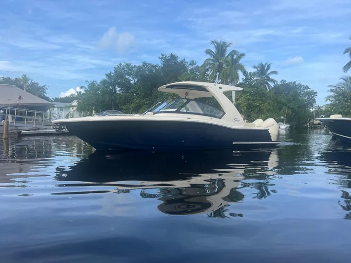  Yacht Photos Pics 2025 Scout 277 Dorado boat on calm water with trees in background.