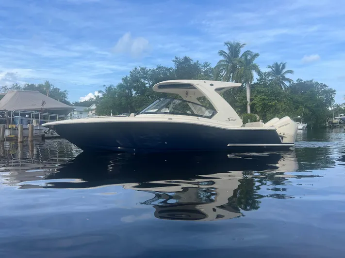  Yacht Photos Pics 2025 Scout 277 Dorado boat on calm water with trees in the background.
