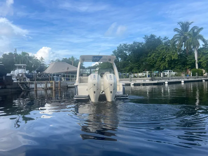  Yacht Photos Pics 2025 Scout 277 Dorado boat docked on calm water under a clear blue sky.