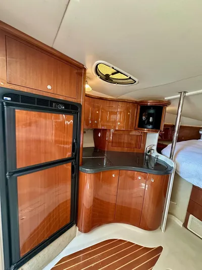  Yacht Photos Pics 2005 Doral Boca Grande yacht interior with wood cabinetry and compact kitchen area.