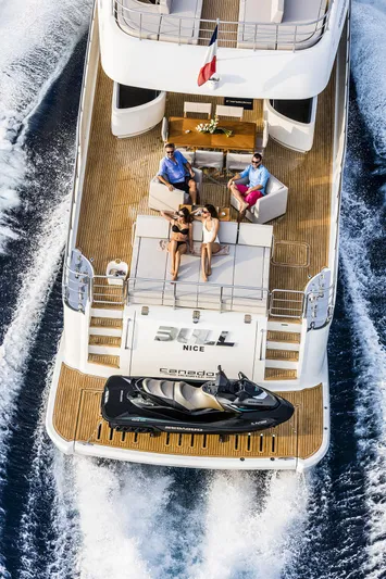 Bull Yacht Photos Pics Luxury Canados 76 GT yacht cruising with passengers, featuring a jet ski on deck.