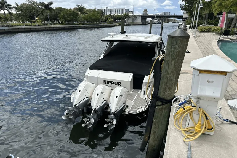  Yacht Photos Pics 2023 Sea Ray 320 DA-OB docked with triple outboard engines, near a waterfront pool.