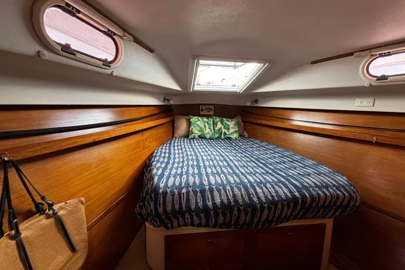 Tortuga Yacht Photos Pics Cozy cabin interior of 2005 Catalina Morgan 440 sailboat with wooden accents and patterned bedding.