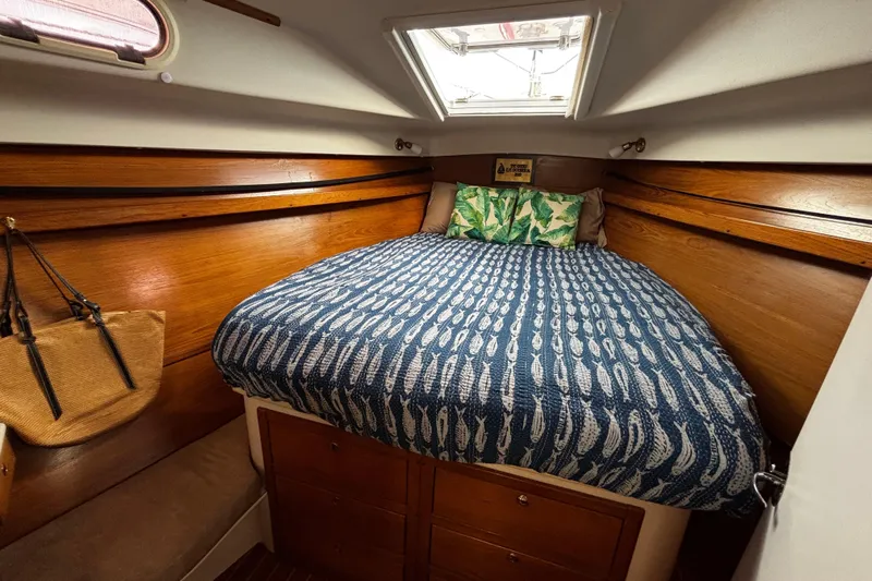 Tortuga Yacht Photos Pics Cozy cabin interior of 2005 Catalina Morgan 440 sailboat with patterned bedding and wooden accents.