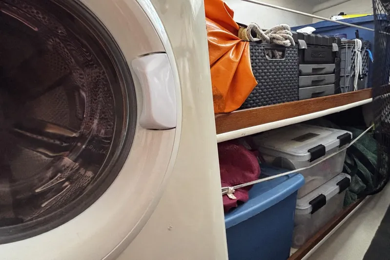 Tortuga Yacht Photos Pics Storage area inside a 2005 Catalina Morgan 440 yacht with organized bins and a washing machine.