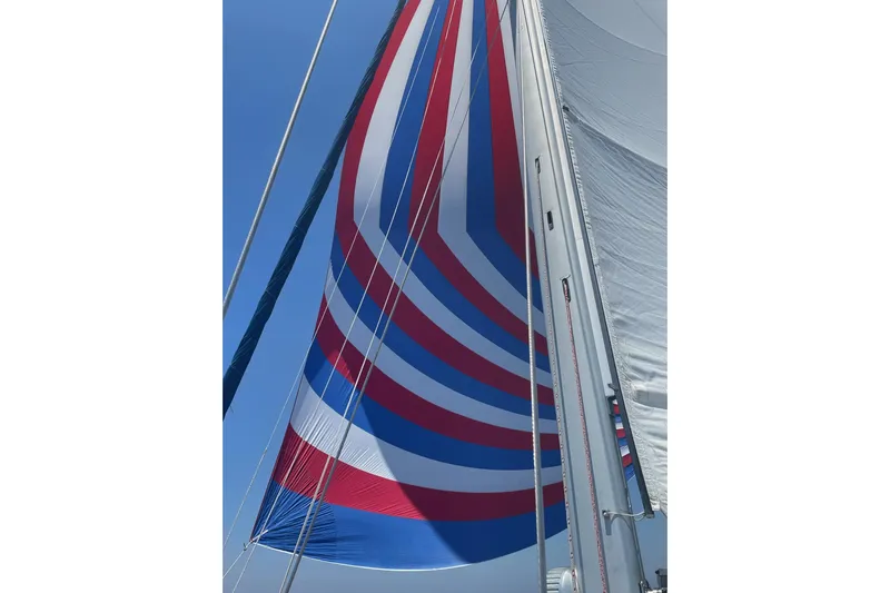 Tortuga Yacht Photos Pics Sailboat with colorful spinnaker sail, Catalina Morgan 440, 2005 model, against clear blue sky.