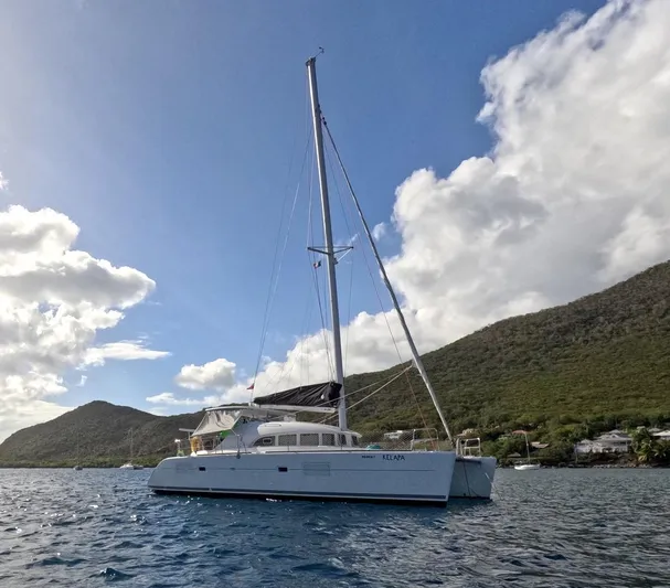 Kelapa Yacht Photos Pics 2016 Lagoon 380 S2 catamaran sailing on blue waters with scenic mountain backdrop.