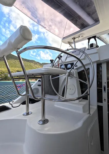 Kelapa Yacht Photos Pics Helm of 2016 Lagoon 380 S2 catamaran with stainless steel wheel and scenic background.