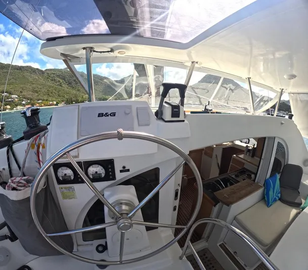 Kelapa Yacht Photos Pics Interior view of 2016 Lagoon 380 S2 catamaran cockpit with steering wheel and navigation equipment.