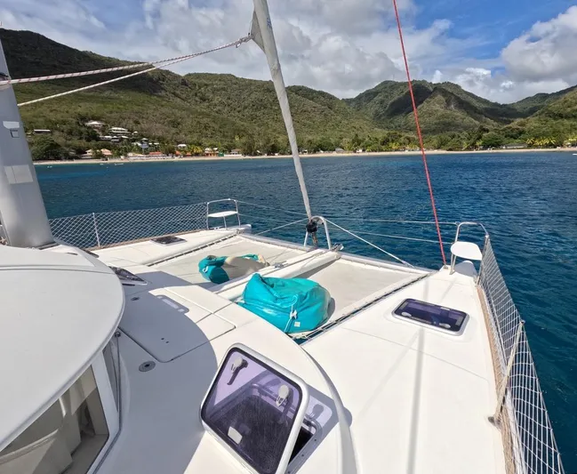 Kelapa Yacht Photos Pics Lagoon 380 S2 catamaran sailing near lush green coastline, 2016 model.