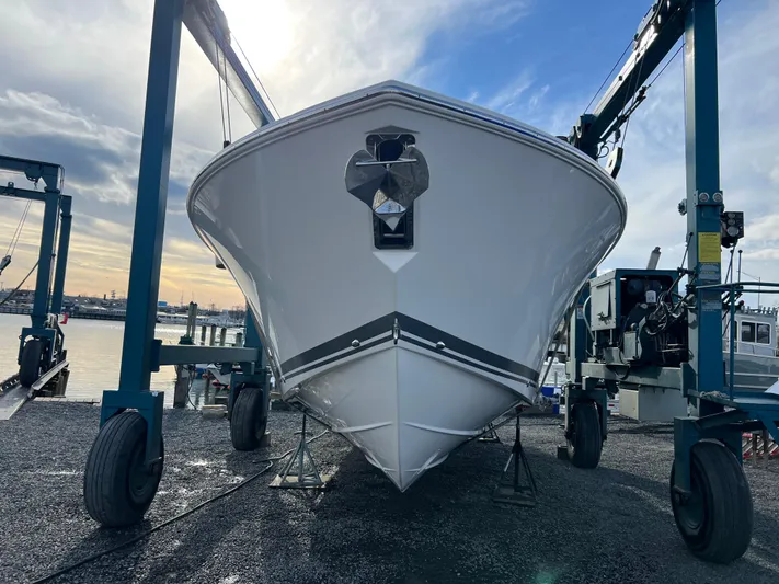  Yacht Photos Pics 2022 Pursuit S 358 boat on a lift at a marina, under a cloudy sky.