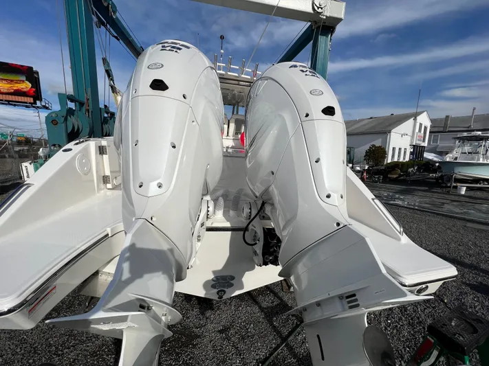  Yacht Photos Pics 2022 Pursuit S 358 boat with dual outboard engines, docked under clear skies.