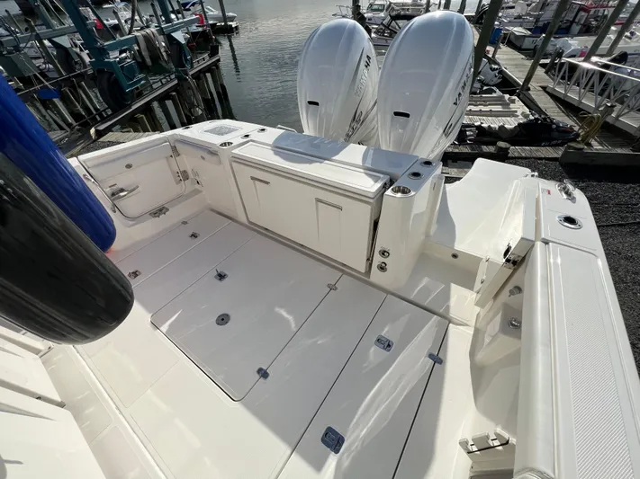  Yacht Photos Pics 2022 Pursuit S 358 boat deck with twin outboard engines at marina.