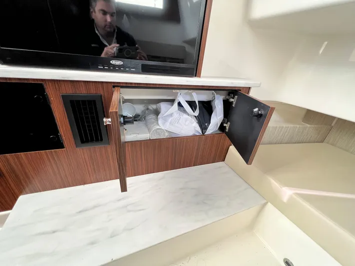  Yacht Photos Pics 2022 Pursuit S 358 interior with open cabinet and TV.