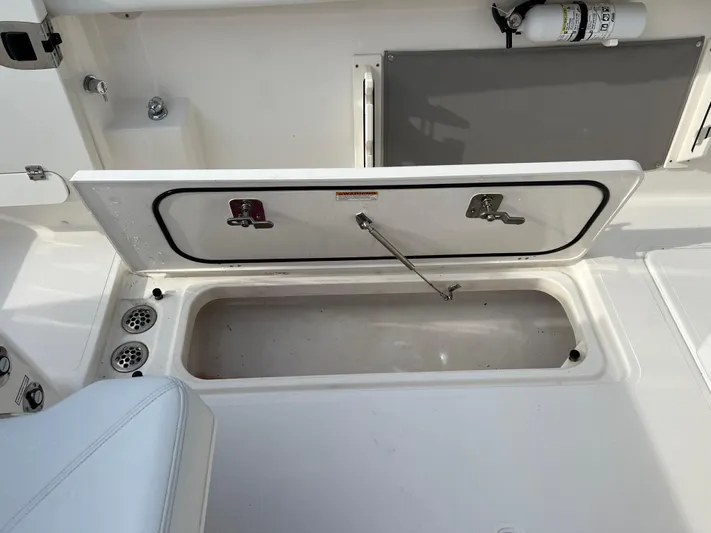  Yacht Photos Pics 2022 Pursuit S 358 boat storage compartment with open hatch and fire extinguisher.