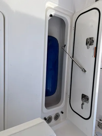 Yacht Photos Pics 2022 Pursuit S 358 boat storage compartment with blue fender inside.