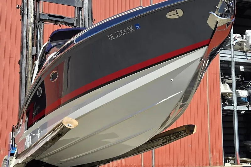 Famous Sport Boat Vibe Yacht Photos Pics 2016 Formula 330 Crossover Bowrider boat lifted in front of a red building.