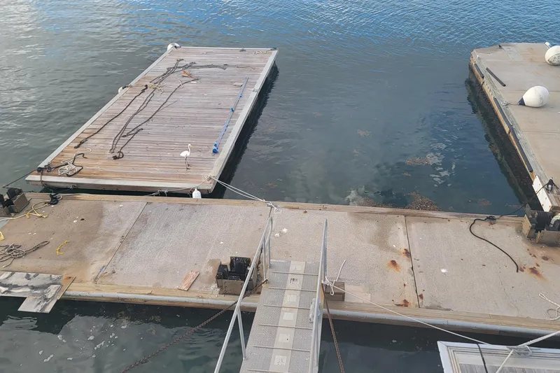  Yacht Photos Pics Floating marina with wooden docks and ropes, featuring a bird, 2003 Custom model.