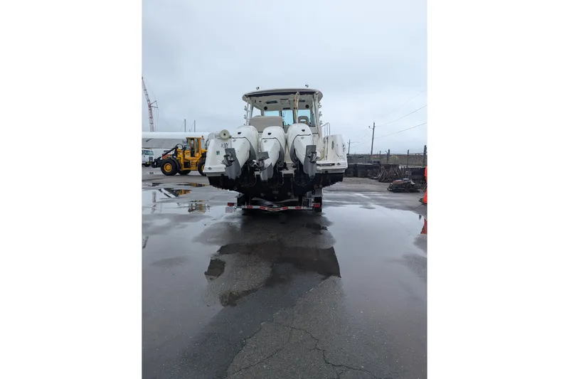 Amy Yacht Photos Pics 2018 Boston Whaler 245 Conquest boat with triple outboard motors on a wet dock.