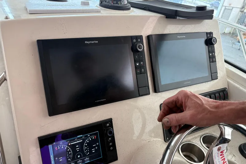 Amy Yacht Photos Pics Control panel of 2018 Boston Whaler 245 Conquest with Raymarine displays and steering wheel.