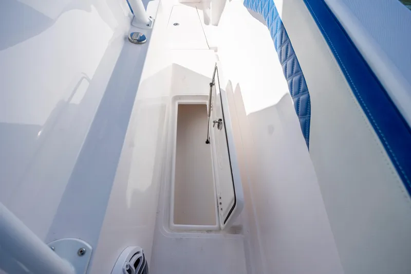  Yacht Photos Pics 2022 Blackwater 36 Sport boat storage compartment with open hatch and blue seating.